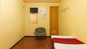 a hospital room with a chair and a bed at RedDoorz near SM Batangas City in Batangas City