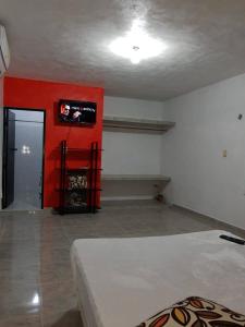 a room with a bed and a tv on a wall at Socktuc in Oxkutzcab