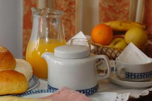 einen Tisch mit einem Krug Orangensaft und einem Obstkorb in der Unterkunft Hotel Eden in Luso