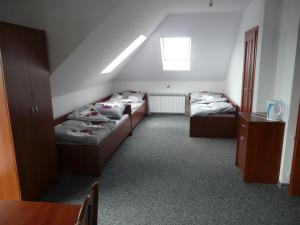 a room with two beds and a table at Noclegi Darex in Pyrzowice