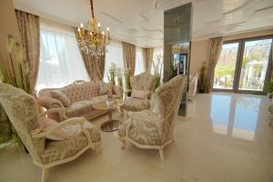 - un salon avec un canapé, des chaises et un lustre dans l'établissement Harmony Suites Saint Vlas, à Sveti Vlas