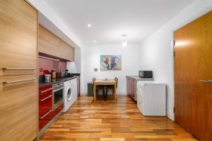a kitchen with a table and a wooden floor at Modern 1BR Apartment near Edgbaston Cricket Ground in Birmingham