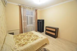 een slaapkamer met een bed, een dressoir en een raam bij Lux Apartment Sobornaya in Nikolayev