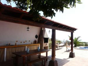 a wooden table in front of a building with a kitchen at Casa Domi in La Esperanza