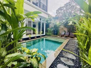 a swimming pool in a garden with plants at OASIS 66 Villa - Heart of Legian/Seminyak - Double Six in Seminyak