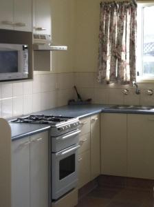 a kitchen with a white stove and a sink at Edgewater Holiday Park in Port Macquarie