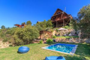 a house with a swimming pool in the yard at Tulbagh Mountain Cabin in Wolseley