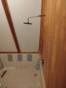 a bathroom with a shower with a light on the wall at Bungalow in Katiet