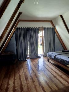 a bedroom with a bed and a large window at Bungalow in Katiet