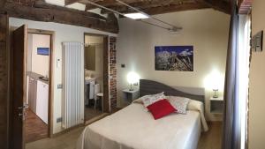 ein Schlafzimmer mit einem weißen Bett in einem Zimmer in der Unterkunft Osteria Senza Fretta Rooms for Rent in Cuneo