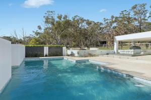 een zwembad met blauw water in een tuin bij La La Land by Coast Hosting in Tascott