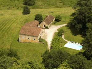 an aerial view of a house with a swimming pool at Impressive restored farmhouse with private pool surrounded by woods in Campsegret