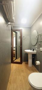 un bagno con lavandino, WC e specchio di Beachfront 4-bedroom home in Kaprovani pine forest a Ureki Altre 38 foto