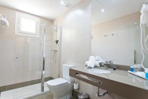 a bathroom with a toilet and a sink and a shower at Porcel Sabica in Granada
