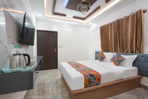 a bedroom with a bed and a television in it at FabHotel Royal Suites I in Bengaluru