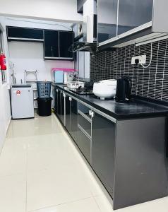 kuchnia z czarnym blatem w kuchni w obiekcie Homestay Ustaz Lumayan w Kuala Lumpur