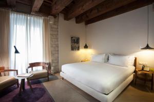 a bedroom with a large white bed and a chair at Mercer Hotel Barcelona in Barcelona +22 photos