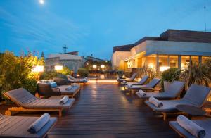 a row of lounge chairs on a deck at night at Mercer Hotel Barcelona in Barcelona