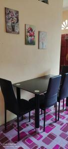 a table and chairs in a room with flowers on the wall at Purnama Homestay in Kampong Bukit Badong