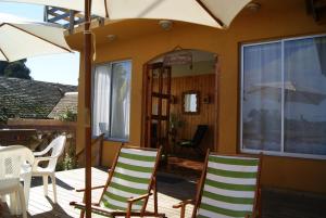 a patio with two chairs and an umbrella at Hostal Libertad in El Quisco