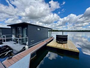 a small cabin on a dock on a body of water at Houseboat Mookerplas met Hottub in Middelaar +27 photos