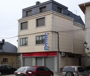a building with cars parked in front of it at Hostal Carmen in El Puente