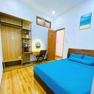 a bedroom with a blue bed and a chair at Mie's Homestay in Da Nang