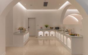 a large white room with an archway and a kitchen at Minos Hotel in Yangshuo