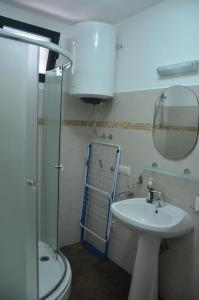 Un baño con inodoro, lavabo y ducha. en Lero Apartments, en Budva