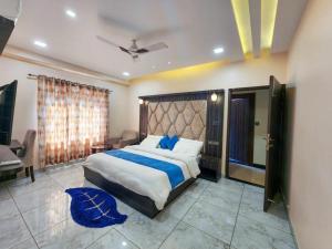 AyodhyaにあるSudama palaceのベッドルーム1室(大型ベッド1台、青いラグ付)