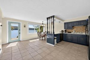 a kitchen with blue cabinets and a table at Lakefront Getaway with Private Dock & Scenic Views home in Gray