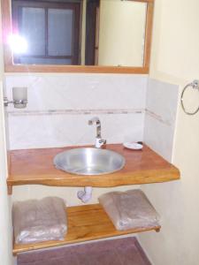 a bathroom with a sink and a mirror at Cabañas El Quijote in Los Reartes