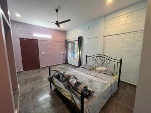 sypialnia z łóżkiem i wentylatorem sufitowym w obiekcie Thi Thi Homestay w mieście Yelagiri