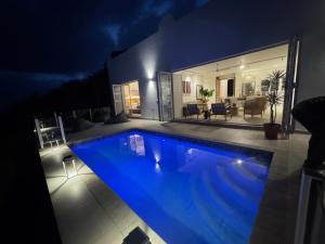 a large swimming pool in a house at night at The Villa At Nakai in Trafalgar