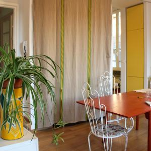 una sala da pranzo con tavolo, sedie e una pianta di Zip b&b . design in Florence a Firenze