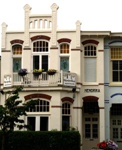 Un grand bâtiment blanc avec balcon est disponible. dans l'établissement Hendrika Apartments, à Zandvoort