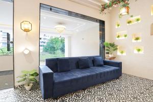 a blue couch in a room with a large mirror at Super Townhouse Haridwar Vishwakarma Ghat Formerly Haridwar Aagman in Haridwār