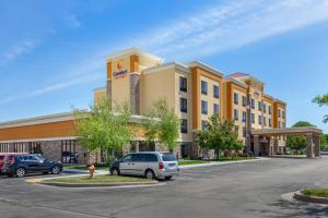 un hotel con auto parcheggiate in un parcheggio di Comfort Suites a Oshkosh