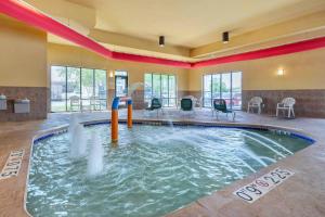 una piscina coperta con scivolo in un edificio di Comfort Suites a Oshkosh