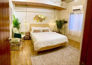 a bedroom with a large bed and a chair at The Bali Farm in Cabuyao