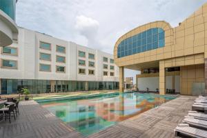 a swimming pool in front of a building at Radisson Blu Hotel, Ludhiana in Ludhiana