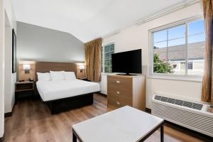 a hotel room with a bed and a window at MainStay Suites Raleigh North in Raleigh