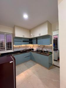 an empty kitchen with blue cabinets and counters at #101 Gokula Srigandha Fragrance in Shimoga +12 photos
