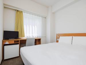 a bedroom with a bed and a desk with a television at Comfort Inn Kofu Isawa in Fuefuki +21 photos
