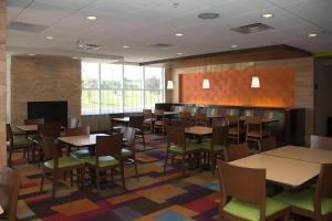 a dining room with tables and chairs and a fireplace at Comfort Inn & Suites in Watervliet +14 photos