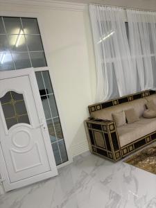 a living room with a couch and a door at منزل للإيجار اليومي in Ḩilf