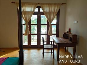 a room with a wooden table and a window at Nade villas madu river wives in Balapitiya