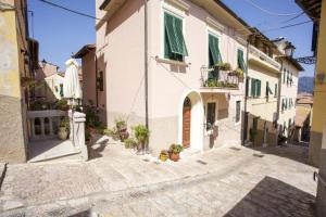 een steegje met witte gebouwen en potplanten bij Appartamento Piazza Il Fico in Portoferraio