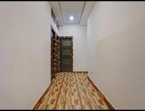 a room with white walls and a wooden floor at Hotel Dhruvas residency in Bengaluru