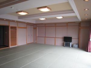 an empty room with a tv in a room at Mamesentaigetsu in Minamichita